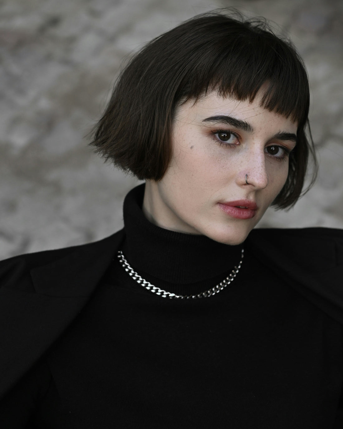 Femme habillée en noir avec un collier ras de cou épais