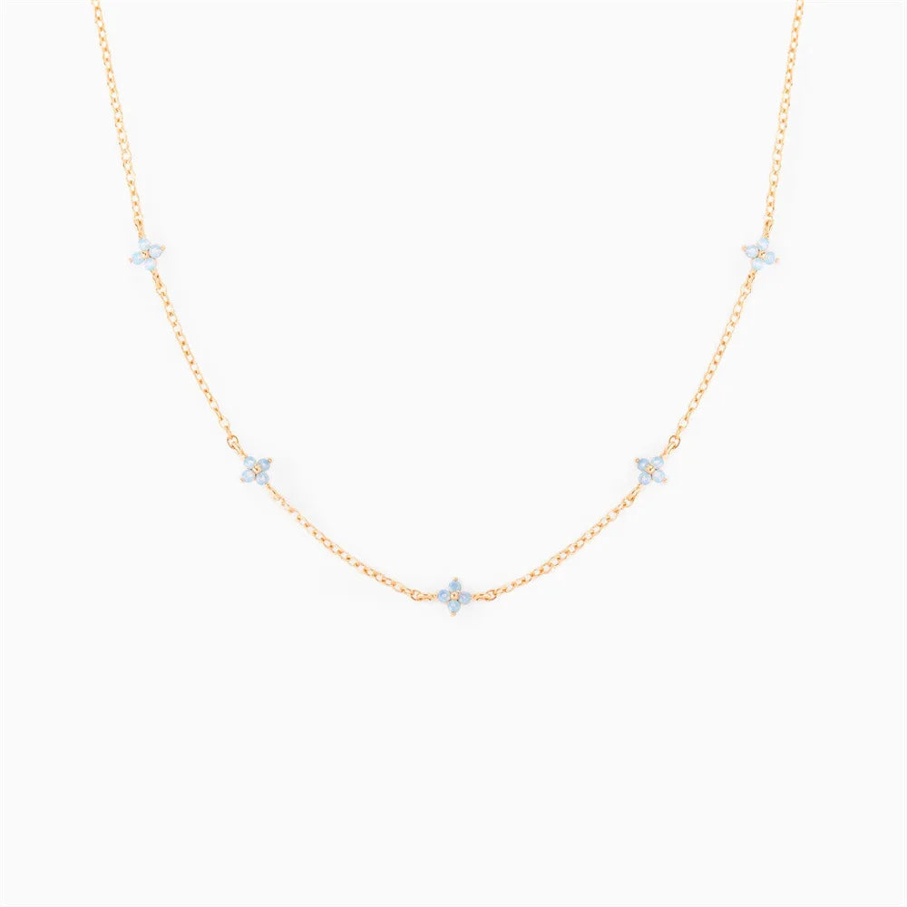 Collier fleur avec une chaîne très fine et des petits motifs de fleurs bleues 